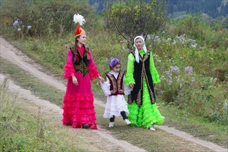 Two Kazakh woman walking with a child