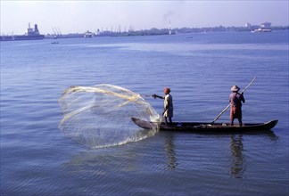 A fisherman fishing by throwing his net