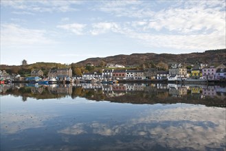 View of boats moored at town harbour in sea loch