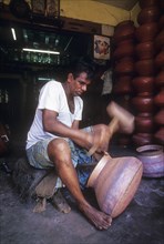 Coppersmith working on a round circular bowl in Kozhikode or Calicut