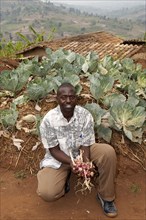 Farmer with produce grown in the keyhole vegetable garden