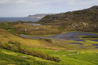 View of rocky hillside overlooking freshwater loch and north coast