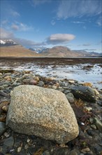 Rocks on shore of fjord during low tide