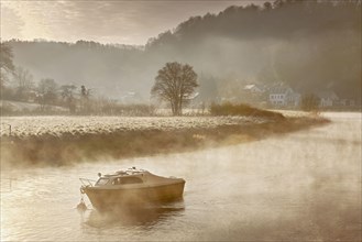 Boat and misty river on frosty morning