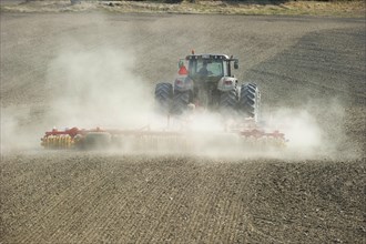Valtra tractor with Vaderstad NZA-800 and Vaderstad RS-820 harrows and rollers working dusty farmland