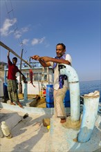 Local fishermen with catch on boat at sea