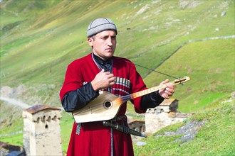 Georgian musician of a folklore group playing panduri