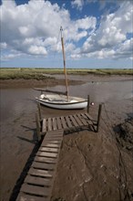 Yacht moored in coastal creek at low tide