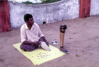 A differently abled beggar with artificial leg
