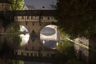 View of bridge over river in city at night