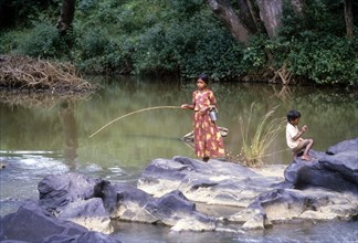 A tribal girl angling in Moyar river