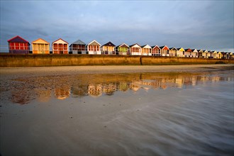Beach huts on the seaside resort dyke at sunrise