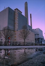 Municipal utility power station at blue hour with reflection in puddle