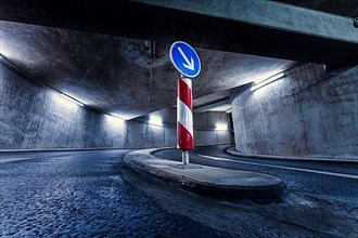 Driveway in underground car park with traffic sign at night