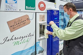 Man draws milk from a vending machine