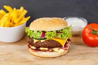 Hamburger cheeseburger fast food meal menu with fries on wooden board in Stuttgart