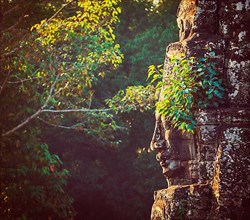 Vintage retro effect filtered hipster style travel image of ancient stone face of Bayon temple