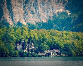 Vintage retro effect filtered hipster style travel image of castle at Hallstatter See mountain lake in Austria. Salzkammergut region