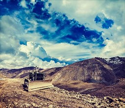 Vintage retro effect filtered hipster style travel image of Bulldozer on road in Himalayas. Ladakh