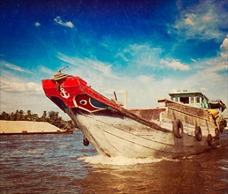 Vintage retro hipster style travel image of boat on Mekong river delta