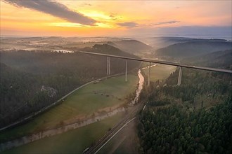Aerial view of the motorway bridge with forest and fog in the sunrise