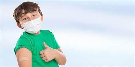 Child Boy With Plaster Inoculating Children Mask Showing Thumbs Up Against Coronavirus Corona Virus copy space Copyspace in Stuttgart