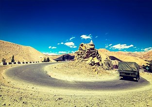 Vintage retro effect filtered hipster style travel image of Road in Himalayas with army truck. Ladakh