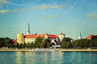 Vintage retro hipster style travel image of View of Riga Castle over Daugava river with grunge texture overlaid. Riga