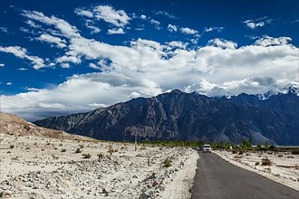 Asphalt road in Himalayas with cars. Nubra valley