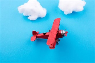 Retro styled little red model airplane in sky