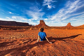 Tourist sitting in red sand