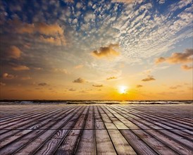 Wooden surface of planks pier under sunset dramatic sky