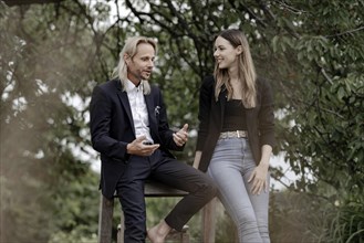 Man and woman talking on a wooden table in nature