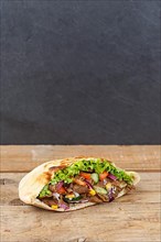 Doener Kebab Doner Kebap fast food meal in pita bread on wooden board with text free space Copyspace in Stuttgart