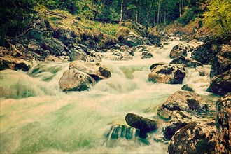Vintage retro hipster style travel image of cascade of Kuhfluchtwasserfall. Long exposure for motion blur. Farchant