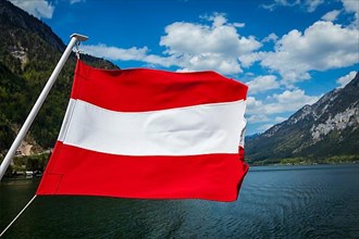 Austrian flag agains mountain lake and Austria alps background
