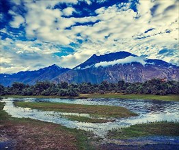 Vintage retro effect filtered hipster style travel image of Panorama of Himalayas and landscape of Nubra valley on sunset. Hunber