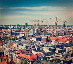 Vintage retro effect filtered hipster style travel image of aerial view of Munich with construction site and cranes