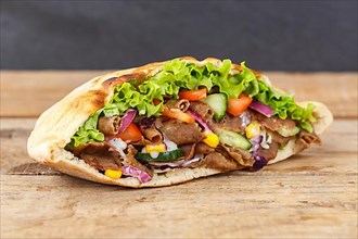 Doener Kebab Doner Kebap fast food meal in pita bread on wooden board in Stuttgart