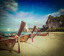 Vintage retro hipster style travel image of Long tail boats on tropical beach