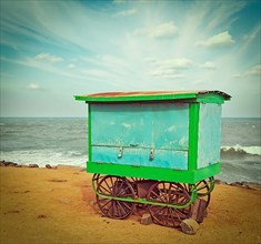 Vintage retro hipster style travel image of cart on beach. Tamil Nadu