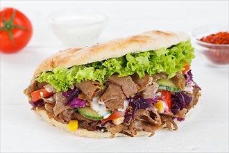 Doener Kebab Doner Kebap fast food meal in pita bread on wooden board in Stuttgart