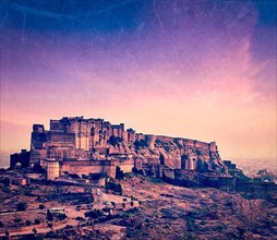 Vintage retro hipster style travel image of Mehrangarh Fort in twilight on sunset