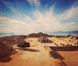 Vintage retro hipster style travel image of ancient civilization ruins on plateau Monte Alban in Mexico with grunge texture overlaid