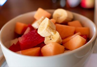 Close up of a cup of banana fruit salad with watermelon