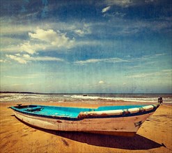 Vintage retro hipster style travel image of boat on a beach