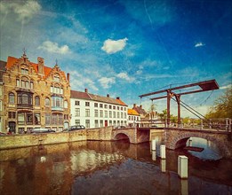 Vintage retro hipster style travel image of canal with old bridge. Bruges