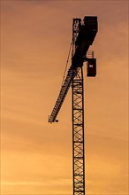 Building crane silhouette in sky on sunset. Munich