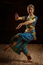 Vintage retro style image of young beautiful woman dancer exponent of Indian classical dance Bharatanatyam in Shiva pose