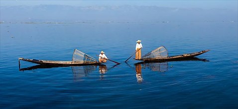 Panorama of traditional Burmese fishermen with fishing net at Inle lake in Myanmar famous for their distinctive one legged rowing style